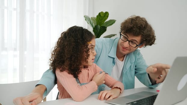 Father explain generate AI while american girl looking at screen. Attractive caucasian dad teaching daughter learning coding engineering prompt and programing system at table with headphone. Pedagogy.