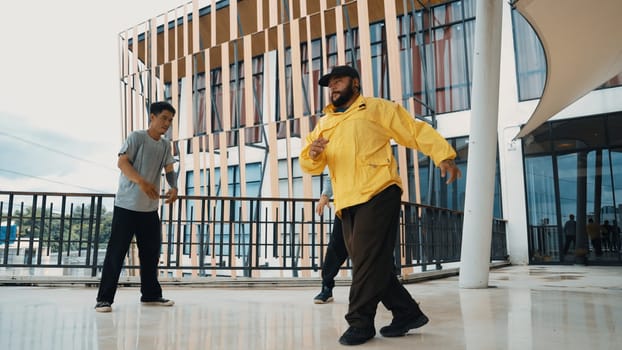 Hip hop team dance break dance while multicultural friend surrounded and clapping hands to cheer or encourage his friend to dance. Active and energetic street dance. Outdoor sport 2024. Endeavor.