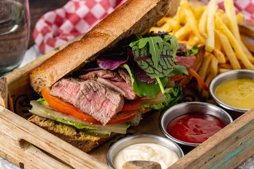 Grilled steak sandwich with french fries on a white porcelain plate