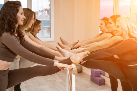 Legs of ballerinas on the barre in the training room.