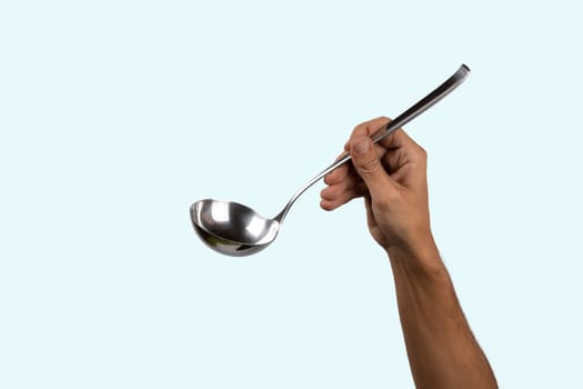 Black male hand holding a silver kitchen ladle isolated on cyan background. High quality photo