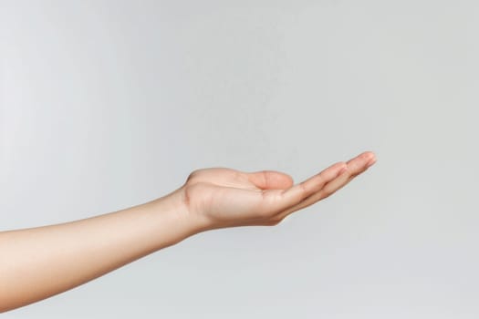 A hand is shown with a white background. The hand is open and extended, with the fingers spread out. Concept of openness and welcoming, as if the hand is ready to receive something or someone