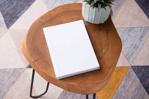 blank book mockup on coffee table with decorations and colorful rug. Template book cover
