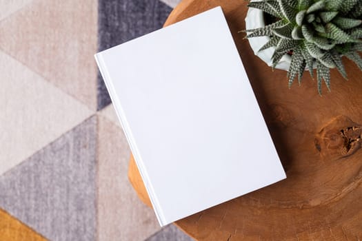 blank book mockup on coffee table with decorations and colorful rug. Template book cover