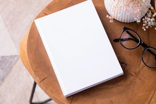 blank book mockup on coffee table with decorations and colorful rug. Template book cover