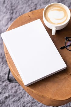 blank book mockup on coffee table with decorations and grey rug. Template book cover