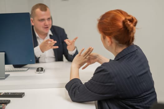Business partners communicate in sign language. A deaf boss gives a task to a subordinate woman