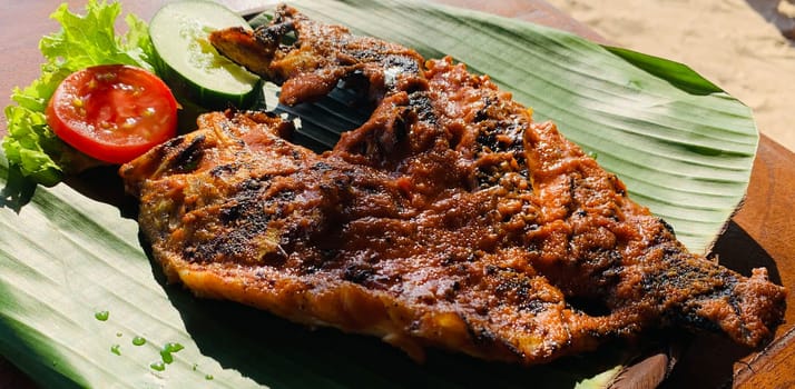 Ikan Bakar Bali, Balinese meal of char grilled snapper fish with traditional sweet salty and spicy sauce in a local food vendor