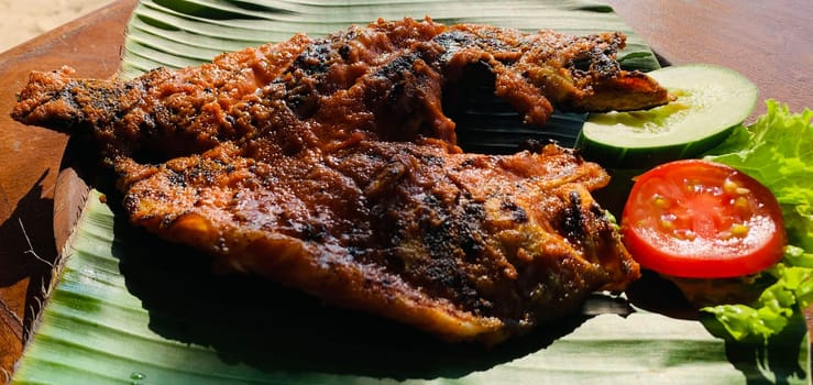 Ikan Bakar Bali, Balinese meal of char grilled snapper fish with traditional sweet salty and spicy sauce in a local food vendor