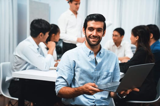 Engineer team leader portrait with diverse group of civil engineer and client working together on architectural project, reviewing construction plan and building blueprint at meeting table. Prudent