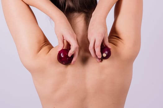 Topless woman with an onion on white background