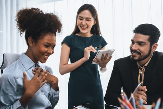 Happy diverse business people work together, discussing in corporate office. Professional and diversity teamwork discuss business plan on desk with laptop. Modern multicultural office worker. Concord