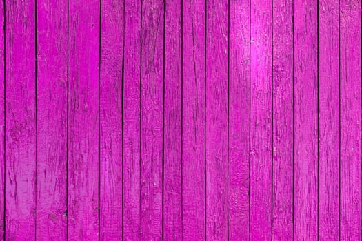 A vibrant close up of a wooden fence painted in one shade of pink color.