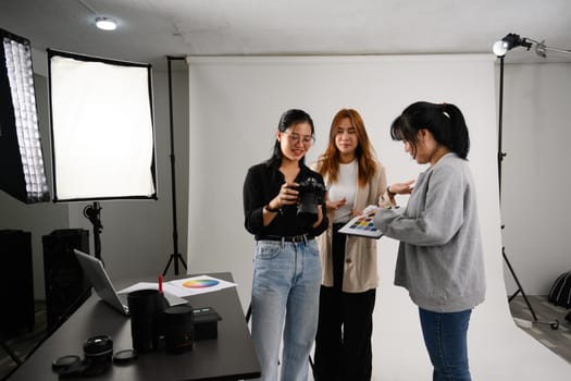 Professional team working together in photo studio with lighting equipment.