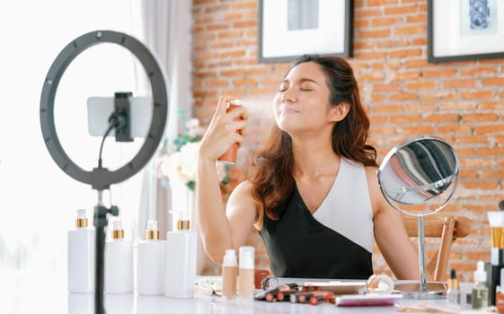 Asian Woman influencer shoot live streaming vlog video review makeup uttermost social media or blog. Happy young girl with cosmetics studio lighting for marketing recording session broadcasting online