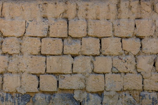 Detailed closeup of beige saman brick wall background and texture.