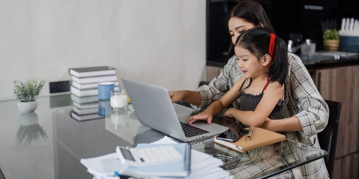 business woman work from home and take care of her child while working.