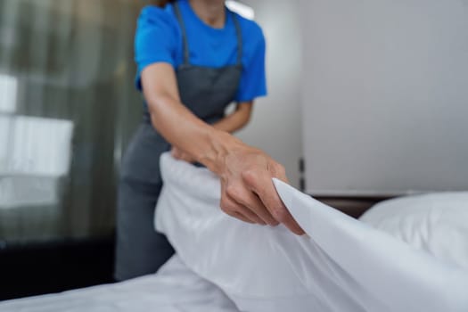 cleaning service woman worker clean bedroom at home. housekeeper cleaner feel happy and make bed look neat. housework and housekeeping cleaning service.