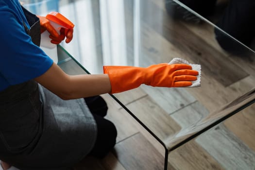 Housekeeping woman wiping the table in the living room House cleaning service concept.