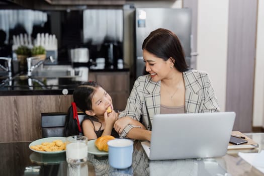 business woman work from home and take care of her child while working.