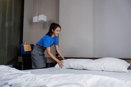 cleaning service woman worker clean bedroom at home. housekeeper cleaner feel happy and make bed look neat. housework and housekeeping cleaning service.