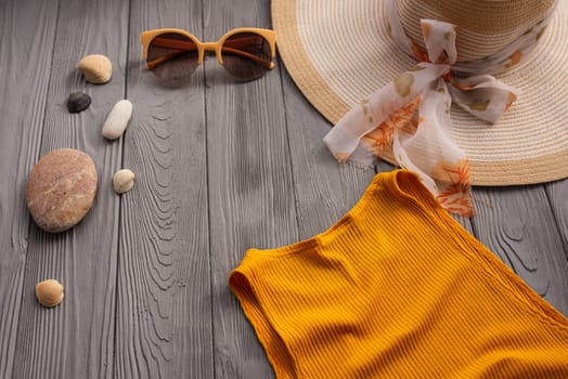 beachwear orange woman top outfit hat bag sun protection sunglasses pebbles. Summer background template mockup free space composition sample text. Top view above wooden background vacation concept