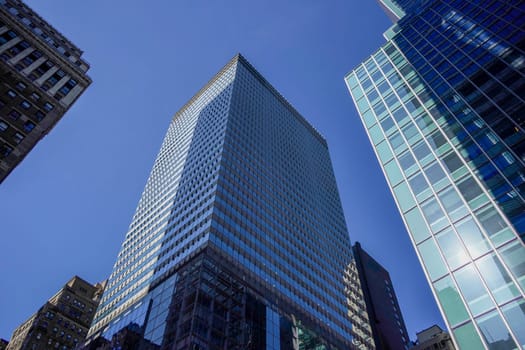 new york city manhattan skyscrapers view from the street to the top of the building on sunny clear day