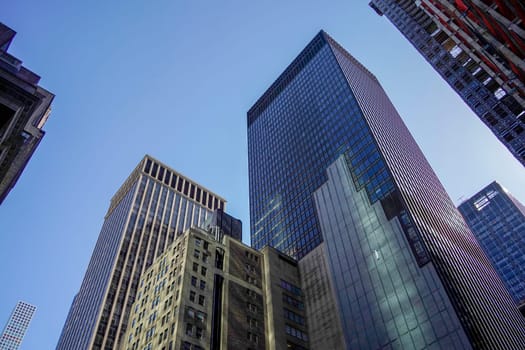 new york city manhattan skyscrapers view from the street to the top of the building on sunny clear day