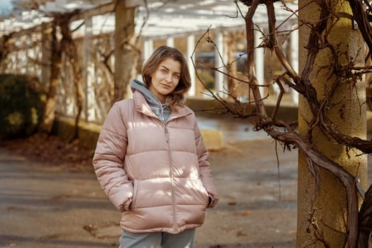 Young beautiful pretty tourist girl in warm hat and coat with backpack walking at cold autumn in Europe city enjoying her travel in Zurich Switzerland. Outdoor portrait of young tourist woman enjoying sightseeing