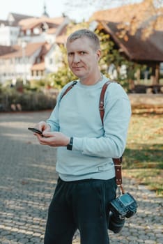 Professional photographer taking picture of beautiful autumn park. man professional photographer sit with camera in autumn park