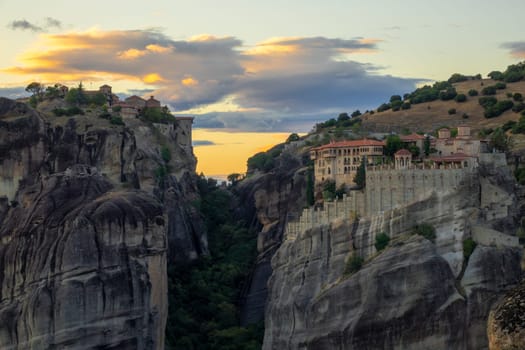 Greece. After sunset summer evening in Kalambaka. Rock monasteries with red roofs. Amazing sunset clouds in the sky