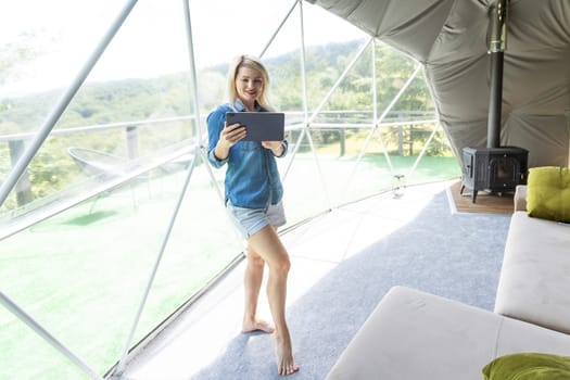 woman with tablet in dome tent. Glamping vacation lifestyle concept
