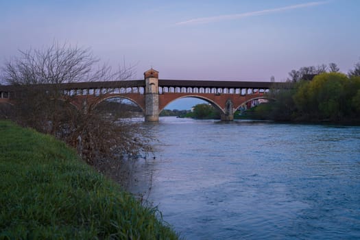 Nice view of Ponte Coperto (covered bridge) is a bridge over the Ticino river in Pavia at blue hour, Lombardy, Pavia, Italy