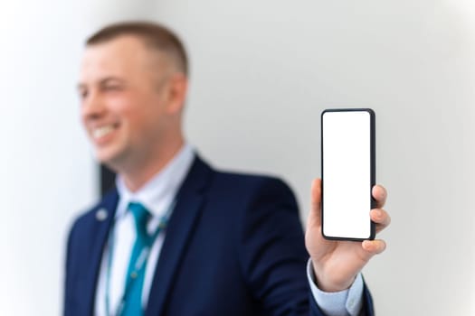 Handsome European Businessman Showing Smartphone With Blank White Screen At Camera. Smiling Caucasian Male Entrepreneur Demonstrating Copy Space, Advertising New App Or Mobile Offer, Collage, Mockup