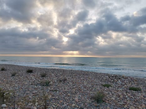 Pebbles of different colors on the beach in the port of Sagunto