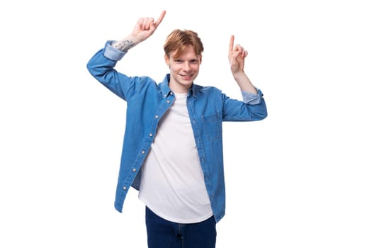 young handsome red-haired guy shows his hands on the advertising space.