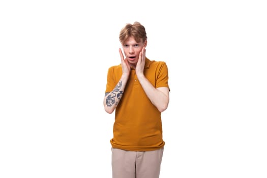 young red-haired guy in a yellow t-shirt is meditating.