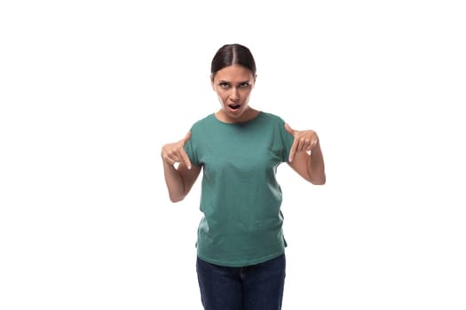 a young woman with black hair and a slender figure dressed in a green T-shirt attracts attention pointing with her hand.