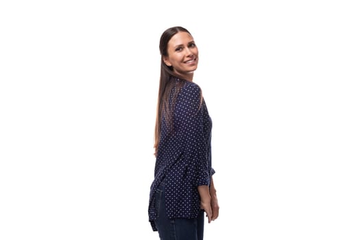 young brunette advertiser woman dressed in a blue blouse with a polka dot pattern looks happy and joyful on a white background with copy space.