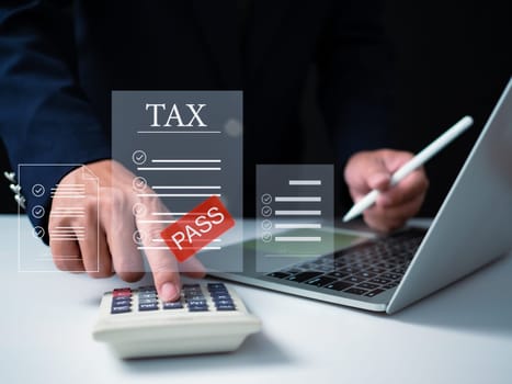 Businessman using computer and calculator for tax calculation, online personal tax return form for tax payment, financial research report, tax return calculation.