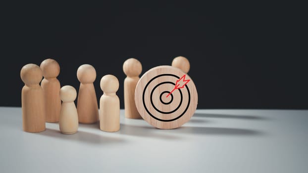 Target concept of business and personnel in a company. wooden dolls standing around Dart board and arrows for creating and targeting business objectives. Marketing solutions, targets for business investment.