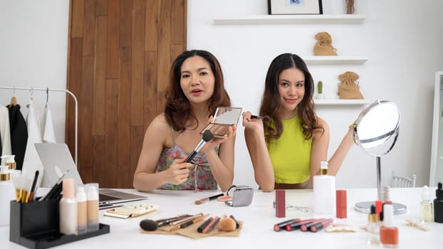 Two influencer partner shoot live streaming vlog video review makeup social media or blog. Happy young girl with vivancy cosmetics studio lighting for marketing recording session broadcasting online.