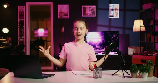 Happy child and her loving mom recording family vlog intro on online platforms. Young smiling daughter and parent warmly welcoming dedicated gen Z fans, filming in home studio with pink neon lighting