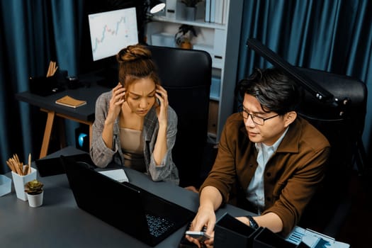 Serious face of sales manager focusing on mobile phone customer with secretary to check waiting on email data at over late night time at modern office. Concept of overworked problem project. Infobahn.