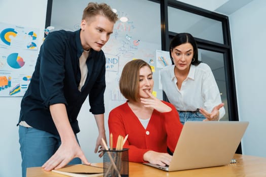 Professional business team working together by using laptop in start up project at meeting in front of glass board with mind map while colleague brainstorm and discuss about strategy. Immaculate.