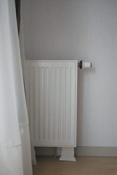 White radiator on grey white wall. apartment heating installation system, .