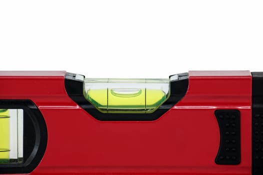 Red spirit level with a green bubble indicator is situated horizontally on a white background