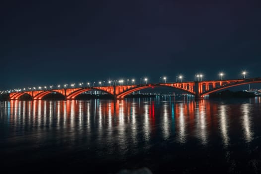 Night view of the famous Communal bridge in Krasnoyarsk through the Yenisei River in Russia, Krasnoyarsk. This bridge is depicted on the 100 rouble bill