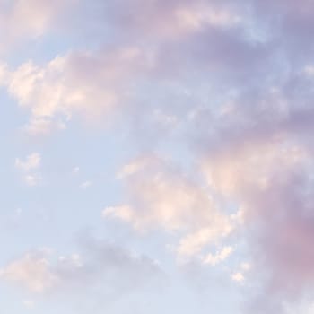 Background of blue sky with pale pink clouds at sunset