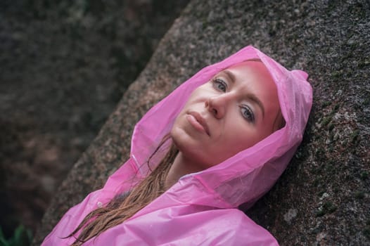 Portrait of woman in the raincoat the taiga forest and rocks of the Stolby nature reserve park, Krasnoyarsk, Russia